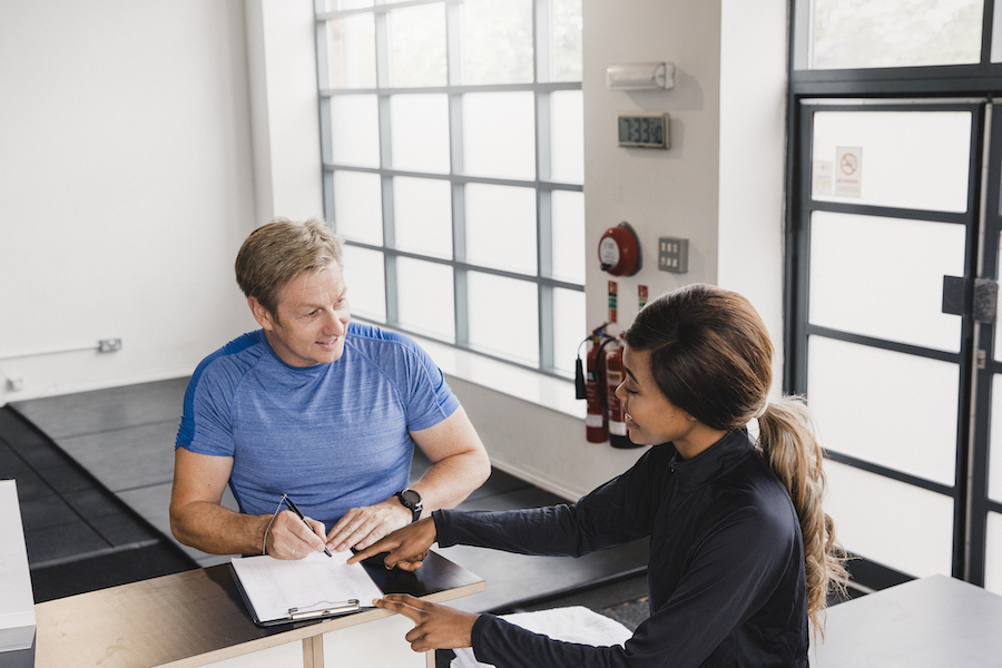 man signing up for personal training session at gym