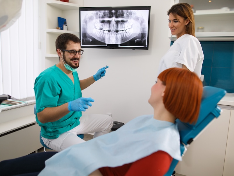 dentist showing X-ray to patient