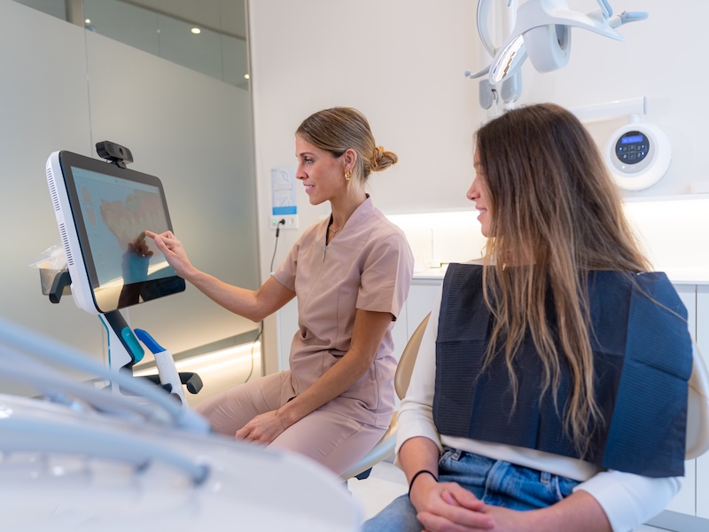 Dentist using AI technology to explain a dental procedure to a patient