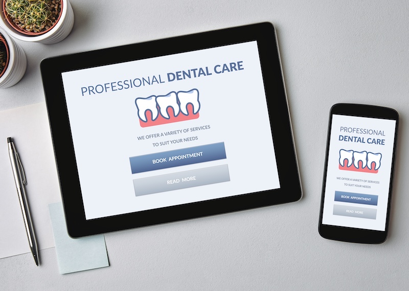 Dental care concept on tablet and smartphone screen over gray table. Top view